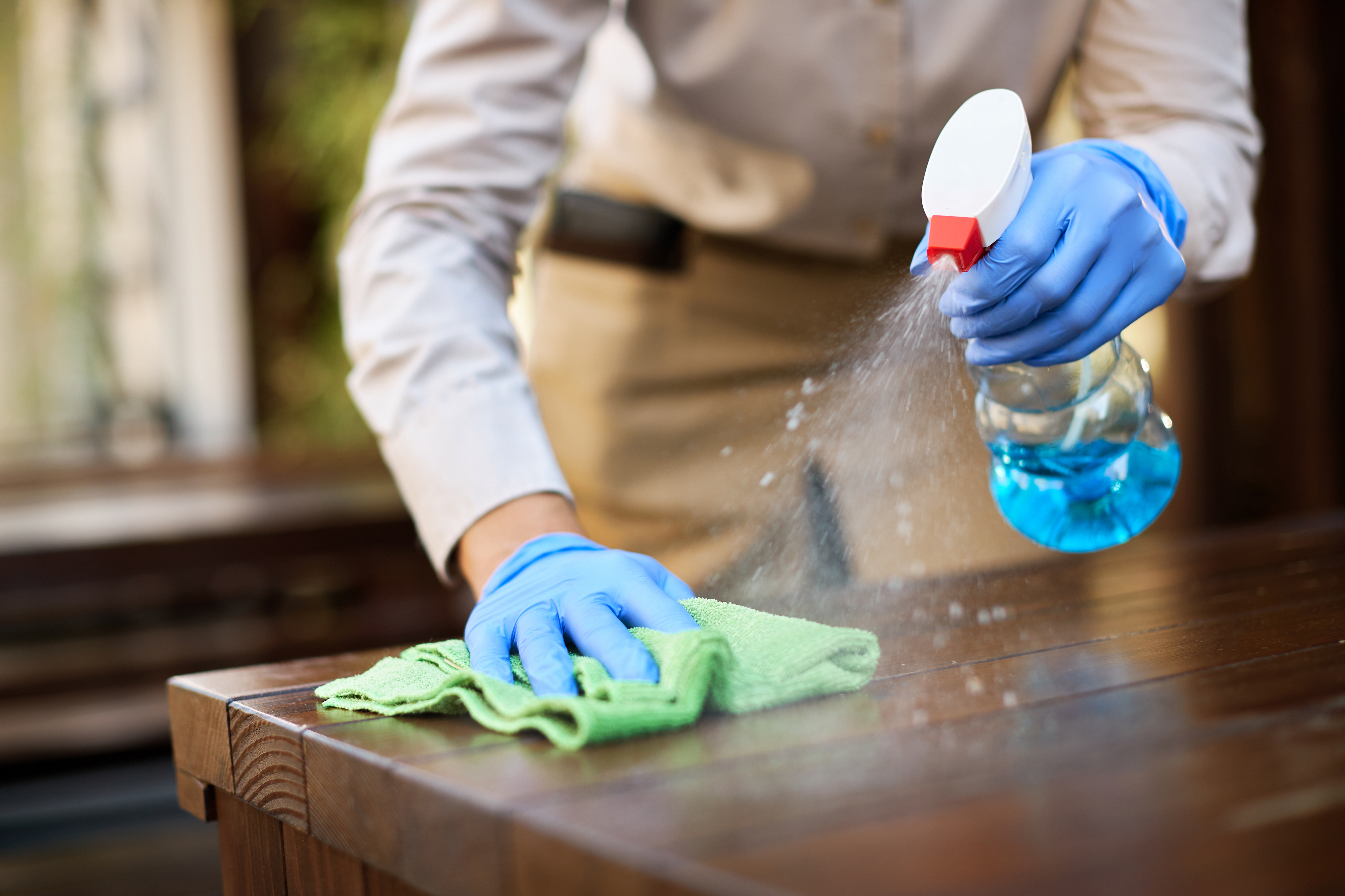 Home close up of waitress disinfecting tables at outdoor cafe.